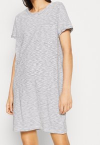 Sukienka t-shirt w paski w kolorze białym i granatowym, krótki rękaw, okrągły dekolt, z kieszonką na piersi, wykonana z miękkiego, lekkiego materiału.