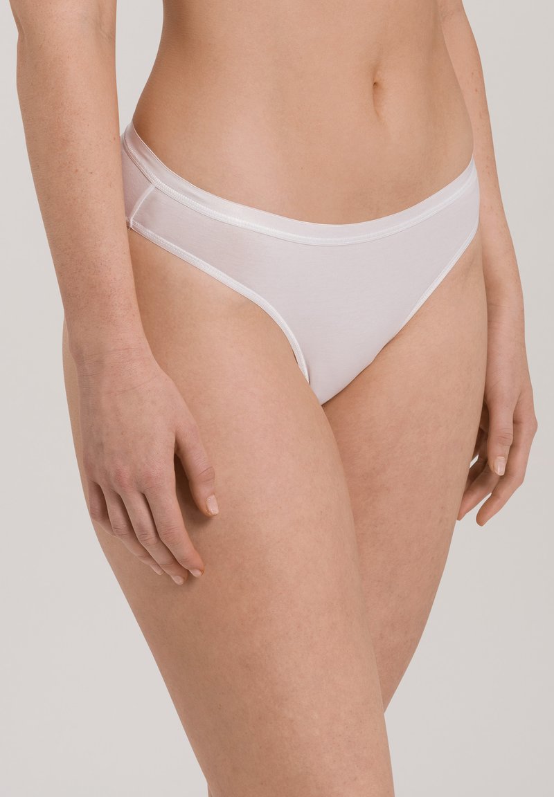 Perizoma bianco in cotone con una texture liscia, caratterizzato da un design a vita bassa e una sottile fascia elastica. Semplice e minimalista, senza motivi o accenti.