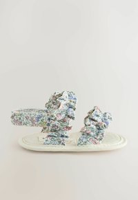 Sandały z kwiatowym nadrukiem, z marszczonymi paskami w pastelowych kolorach, z płaską plecioną podeszwą i teksturowanymi detalami.