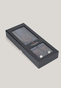 Szare materiałowe szelki w czarnym pudełku, z brązowymi skórzanymi akcentami i metalowymi klipsami, widoczne przez przezroczysty front.