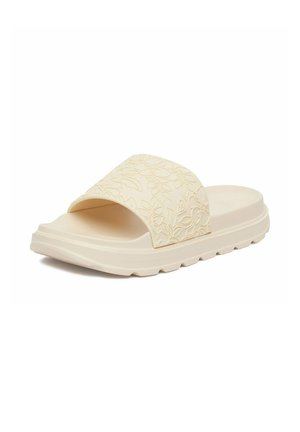 Sandale à enfiler beige avec une semelle épaisse et une large bride avec des motifs floraux en relief, vue en angle sur fond blanc.