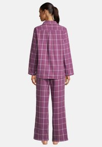 Paarse geruite pyjama set met een блуждающие shirt en lange broek. Stof lijkt zacht met een ruitpatroon, met lichte accenten op de ruiten.