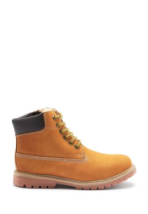 Braune Wildleder-Stiefelette mit schwarzem gepolstertem Kragen, goldenen Ösen und beigem Nähten. Verfügt über eine dicke Gummisohle mit Traktionsrillen.