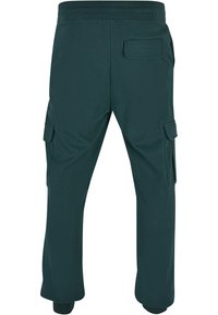 Pantaloni cargo de culoare verde închis, dintr-un material moale, cu buzunare laterale, un buzunar posterior și manșete elastice la glezne.