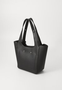 Sac fourre-tout noir texturé avec des anses en tissu, doté d'un intérieur spacieux et de deux clous décoratifs en métal à l'avant.