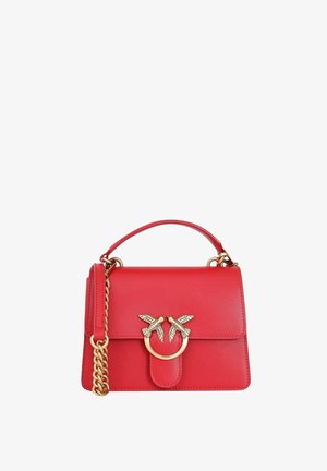 Sac à main en cuir rouge avec bandoulière chaîne dorée et fermoir doré orné de deux oiseaux s'embrassant sur le rabat avant.