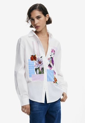 Weißes Langarmshirt mit bunten Blumen- und gestreiften Patches, mit Button-down-Kragen und lässiger Passform. Aus Baumwollmaterial, mit strukturiertem Design.