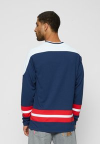 Cămașă pe mânecă lungă de culoare bleumarin, cu accente albe și roșii, având guler rotund și detalii în dungi la manșete și la tiv. Material texturat.