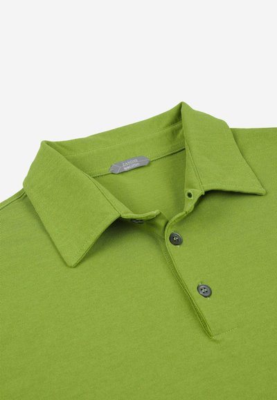 Camisa polo verde con cuello, tres botones negros y una suave tela de algodón texturizada. La etiqueta dice "Zanone Icecotton."