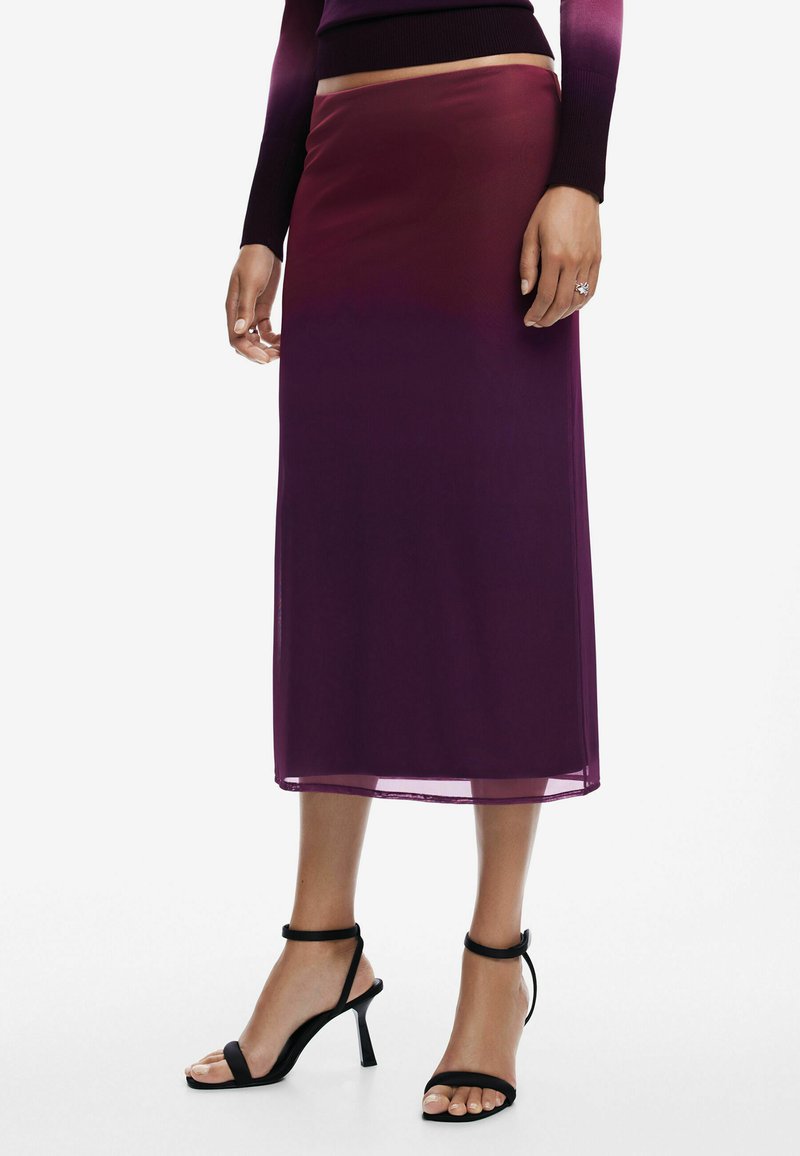 Durchsichtiger lila Midirock mit Ombre-Effekt, der über eine glatte Textur und einen schrägen Saum verfügt. Kombiniert mit schwarzen, trägerlosen High Heels.