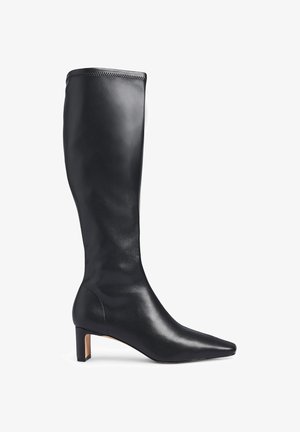 Black knee-high boot made of smooth leather. Features a pointed toe and a moderate block heel, with visible seam detailing at the top.