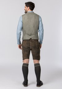 Zweiteiliges Outfit mit einem hellblauen Hemd, einer grauen Leinenweste, braunen Lederhosen und grauen Kniestrümpfen, ergänzt durch schwarze Schuhe.