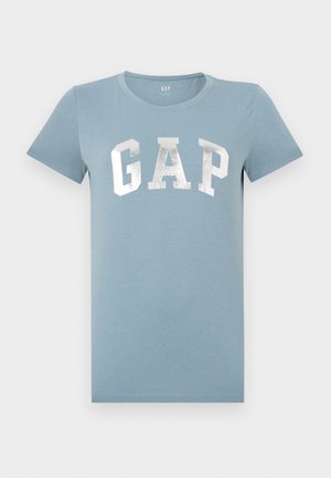 Maglietta azzurra chiaro a maniche corte con scollo rotondo e logo "GAP" argentato e brillante sulla parte anteriore.