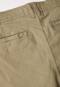 Khaki puuvillapantsit, joissa on sileä rakenne, kaksi takataskua, hillityt ompeluyksityiskohdat ja suora lahje.