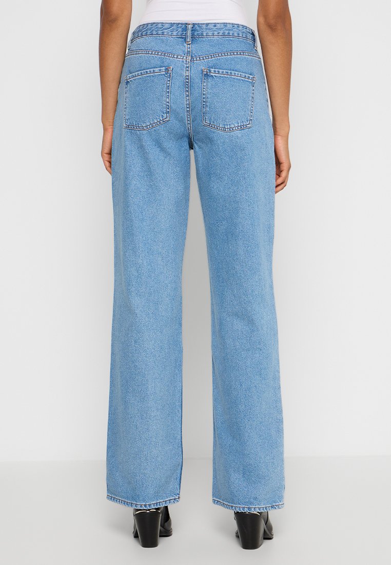 Jasnoniebieskie, wysokie dżinsy z szerokimi nogawkami, z dwoma tylnymi kieszeniami i kontrastowym przeszyciem. Gładka tekstura i klasyczny design.