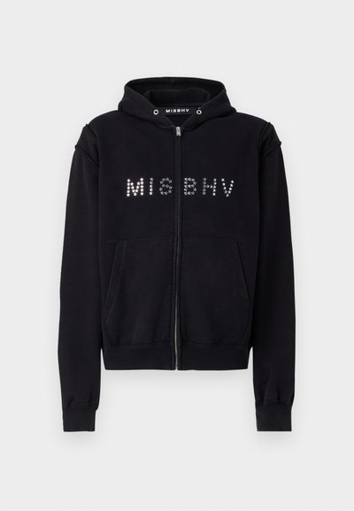 Black zip-up hoodie with a kangaroo pocket, embellished with metallic studs forming "MISBHV" across the chest and a drawstring hood.