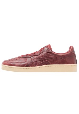 Baskets basses en cuir bordeaux avec perforations, bandes de couture ton sur ton, lacets bordeaux et semelle en caoutchouc beige.