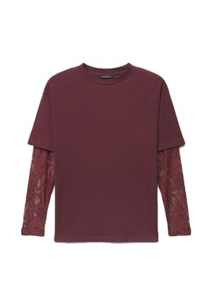 Top a manica lunga color bordeaux con sovrapposizione di maniche corte tinta unita e maniche con trama in pizzo che si estendono da sotto le maniche corte.