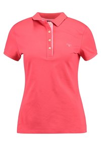 Rosa Polo-Shirt aus Baumwolle, mit Kragen, kurzen Ärmeln, Knopfleiste mit drei Knöpfen und einem kleinen Logo auf der Brust.
