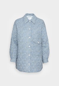 Quilted shirt jacket in light blue with a floral pattern, featuring a collar, button front, and single chest pocket. Smooth fabric texture.