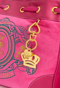 Borsa a mano fucsia con superficie testurizzata, hardware dorato e ricami dettagliati con un ciondolo a forma di corona e cuciture decorative.