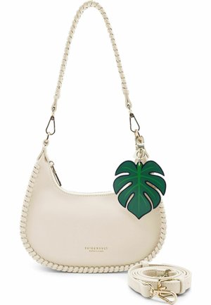 Bolso de cuero crema en forma de media luna con ribete de pespunte, correa de hombro desmontable y colgante verde de hoja de monstera unido al asa.
