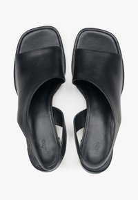 Zwarte leren sandalen met een gladde textuur, brede bovenband, open hiel en platte zool met een minimalistisch ontwerp.