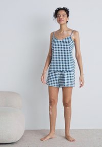 Blue and white checkered pajama set with a v-neck top and matching shorts, made from lightweight fabric, displayed against a plain background.