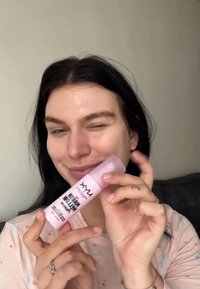 NYX primer in a cylindrical pink bottle, featuring a black font label. The bottle has a smooth texture with a flip-top cap.
