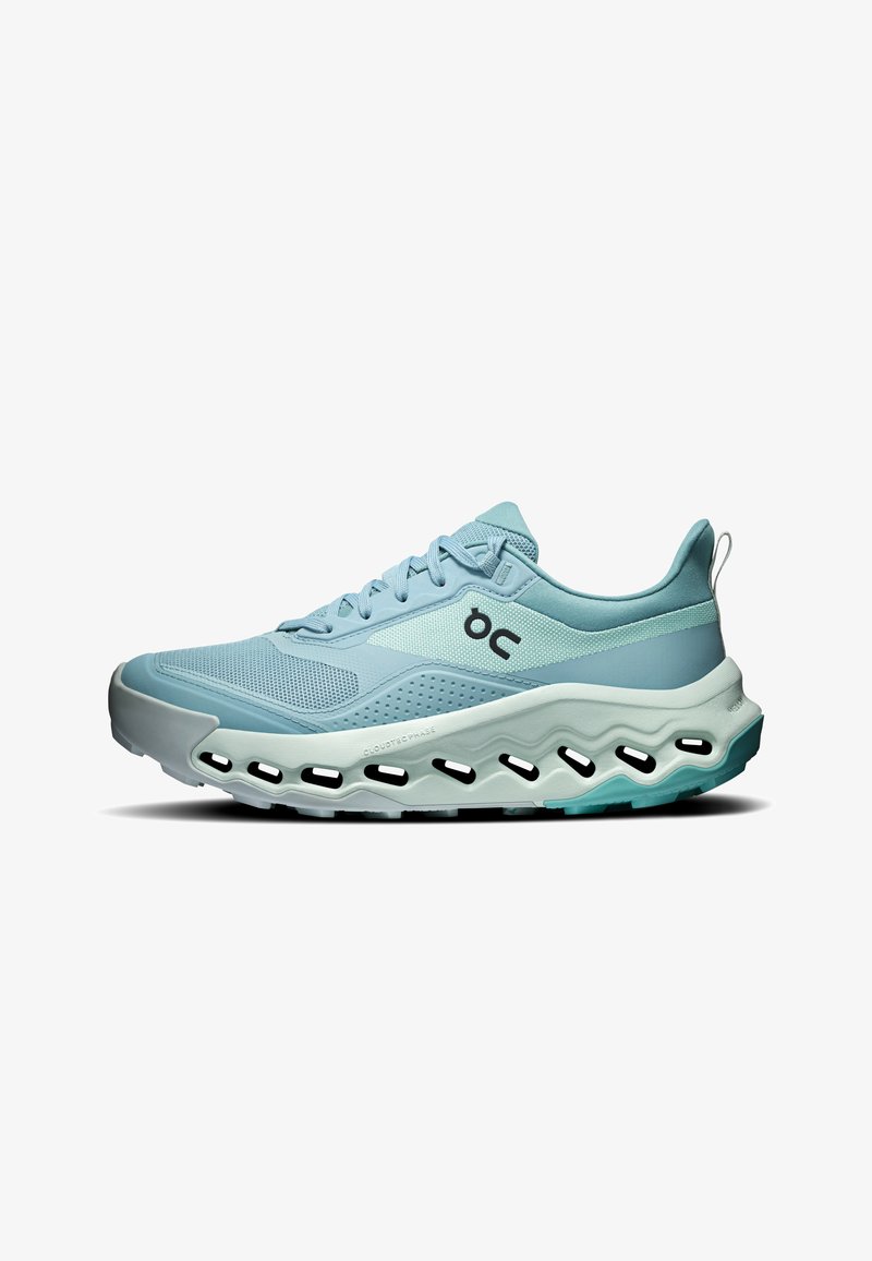 Baskets de sport bleu clair avec tige en mesh, fermeture à lacets, logo ON et semelle épaisse ondulée avec découpes visibles, vue de côté.