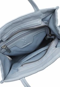 Light blue leather handbag interior with two zippered pockets and open compartments, featuring a soft texture and silver hardware accents.