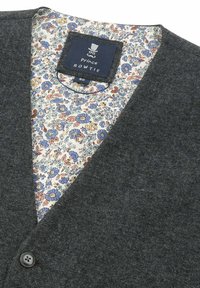 Dunkelgrauer Cardigan mit V-Ausschnitt, ausgestattet mit einem floral gemusterten Innenfutter in Blau, Orange und Creme, sowie einem einzelnen Knopfverschluss.