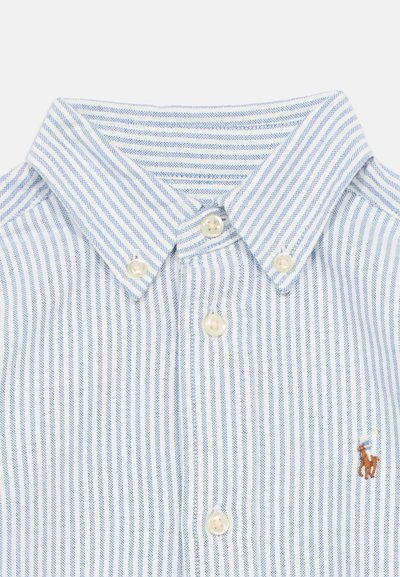 Ανοιχτό μπλε και λευκό ριγέ πουκάμισο με κουμπιά και γιακά. Διαθέτει πέρλες κουμπιά και μικρό κεντημένο λογότυπο με άλογο.