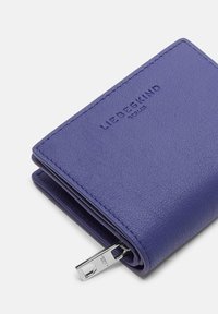 Złożony niebieski skórzany portfel z wytłoczonym logo "LIEBESKIND BERLIN" i srebrnym uchwytem suwaka na białym tle.