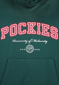 Sudadera verde con el gran texto rojo "POCKIES" encima de "Universidad de Mediocridad" en blanco, con un logo y estrellas de acento debajo.