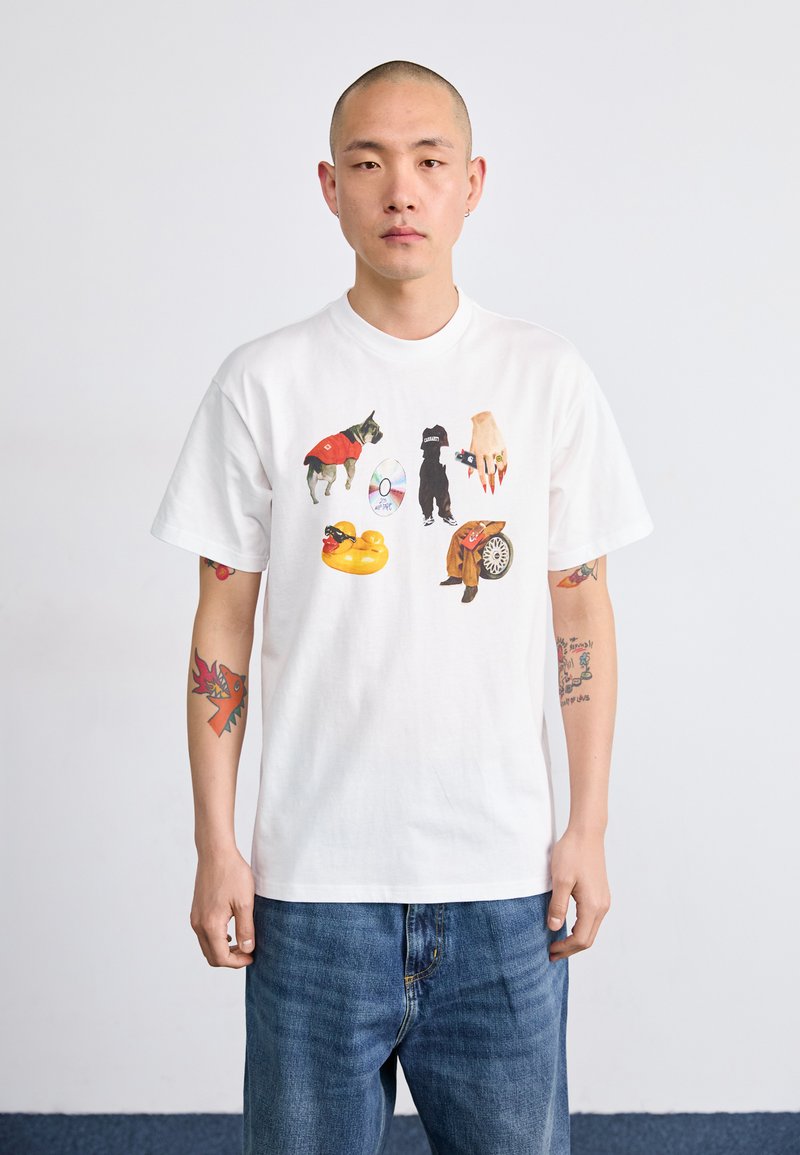 White cotton t-shirt featuring colorful prints of dogs, a hand, a disc, and a pool float. The fit is relaxed with short sleeves.
