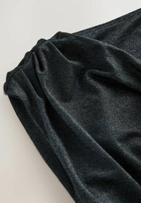 Czarny, teksturowany materiał o subtelnym połysku i marszczonym detalu. Gładka powierzchnia z delikatnymi poziomymi liniami, układająca się miękko.