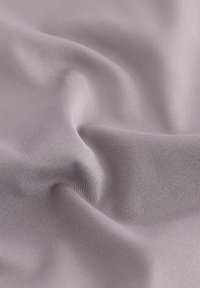 Lilla stof med en glat, let strakt tekstur og fine ribber. Materialet ser fleksibelt og blødt ud at røre ved.