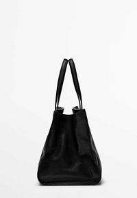 Sac fourre-tout en cuir noir avec une forme triangulaire structurée. Doté de deux poignées fines et d'une texture lisse. Aucune quincaillerie visible ni motifs.
