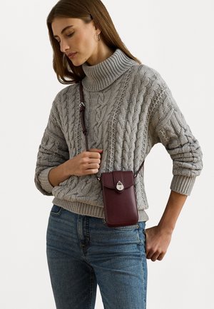 Fitted gray cable-knit sweater, high collar, paired with a burgundy crossbody phone case featuring a snap closure and adjustable strap.