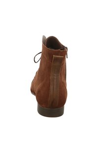Braune Wildleder-Stiefeletten mit einer konischen Form, ausgestattet mit einem seitlichen Reißverschluss, hellbraunen Akzenten und einer glatten, flachen Gummisohle.