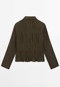 Blouse olive foncé à manches longues avec col et texture de tissu froncée sur le panneau arrière.
