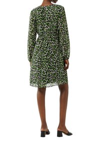Grünes und schwarzes Leopardenmuster-Kleid mit langen Ärmeln, elastischem Bund, fließendem Stoff, knielang und rundem Ausschnitt.