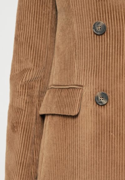 Rjava kordna blazer z navpičnim ribanjem, dvobarvnim zapiranjem in enim stranskim žepom. Gladka tekstura z mat zaključkom.