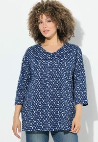 Tunic blu navy con motivo a diamante in azzurro chiaro. Presenta un scollo a V, maniche a tre quarti e una vestibilità comoda. Texture del tessuto morbida.