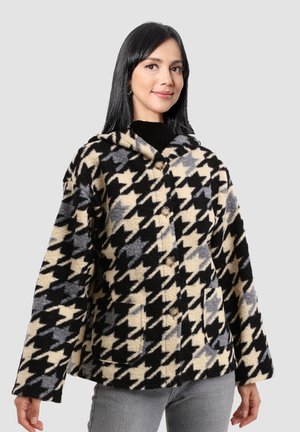 Chaqueta con capucha de patrón de espiga en negro, crema y gris, con un corte relajado, dos bolsillos frontales y cierres de botón.