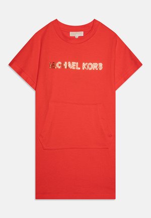 Red cotton t-shirt featuring a central pocket, round neckline, and "MICHAEL KORS" printed in reflective lettering across the chest.