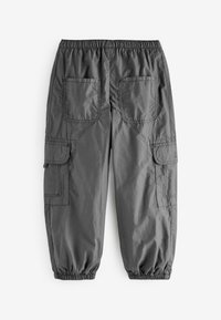 Pantaloni cargo grigi con cintura elastica, numerose tasche laterali e polsini elastici alla caviglia. Realizzati in tessuto leggero e liscio.