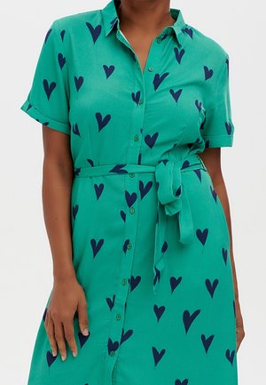 Tyrkysově modré košilové šaty s krátkými rukávy a páskem, zdobené vzorem rozmístěných námořnicky modrých srdcí na látce.
