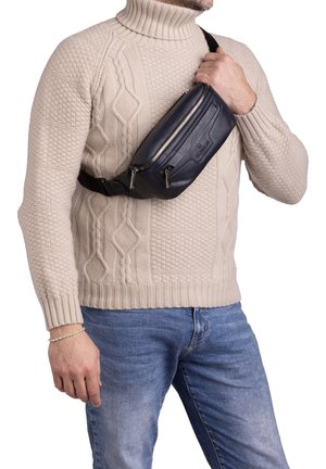 Navy blue leather sling bag features two zippered compartments, a smooth texture, and adjustable black strap for crossbody wear.